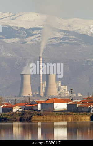 Un impianto di generazione di energia elettrica alle spalle di un lago e di un villaggio nel nord della Grecia Foto Stock