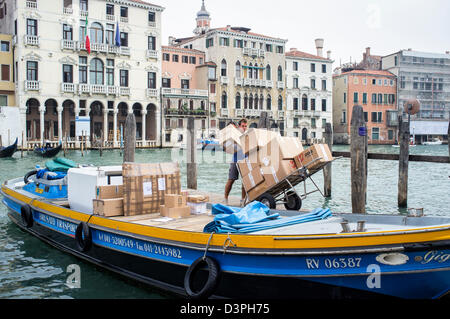 Consegna Barge e uomo sul Canal Grande a Venezia Foto Stock