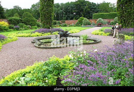 Il giardino murato con uno stagno circondato da statue e una moderna scultura di fiori a Arley Hall gardens Cheshire England Regno Unito Foto Stock