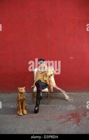 Voce maschile seduto da solo con oro cheetah Foto Stock