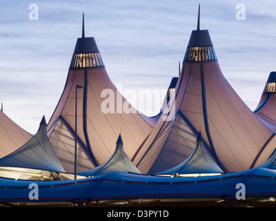 Incandescente tende di dia a sunrise. L'aeroporto internazionale di Denver ben noto per tetto a falde. design del tetto è riflettente montagne innevate. Foto Stock