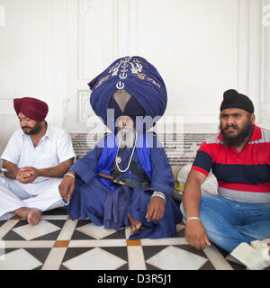 Nihang seduta Sikh in tradizionali abiti religiosi, Tempio Dorato, Amritsar Punjab, India Foto Stock