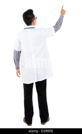 Corpo pieno vista posteriore di Asian medico rivolto verso lo spazio vuoto in piedi isolato su sfondo bianco Foto Stock