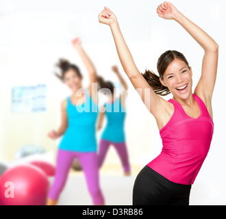 Ritratto di felice energetic woman dancing zumba nella classe di aerobica Foto Stock