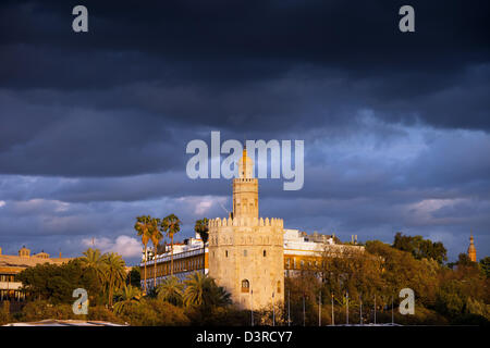 New Scenic 5 posti Torre del Oro (Gold tower) al tramonto con nuvole temporalesche al di sopra di Siviglia andalusia regione. Foto Stock