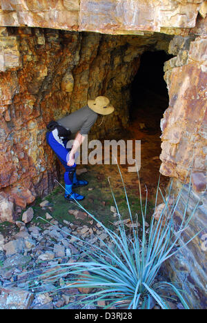 River runner cercando nell'apertura di una miniera abbandonata vicino al fiume di sale, Arizona. Foto Stock