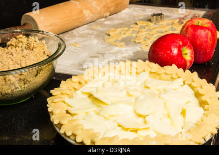Una fetta di torta di mele preparata di fresco e pronto per il forno con coppa e mele Foto Stock