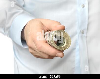 Un rotolo di dollari in una mano Foto Stock