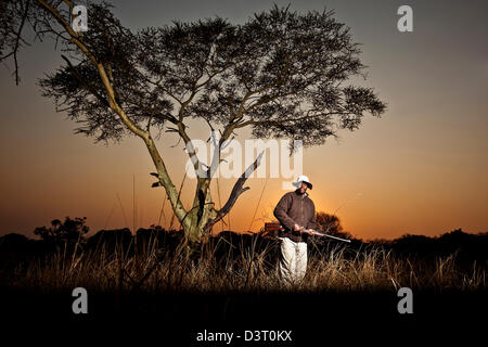 Safari ranger si erge con un fucile in Phinda Game Reserve, Sud Africa Foto Stock