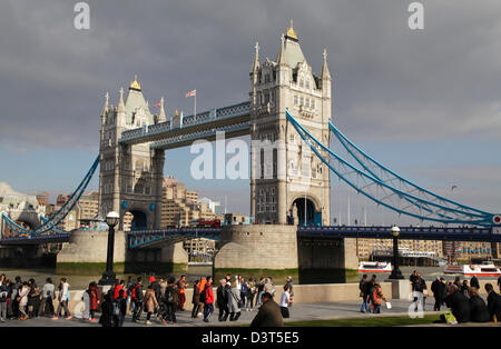 I turisti a piedi lungo la riva sud sulla soleggiata giornata invernale e presso il Tower Bridge di Londra Inghilterra REGNO UNITO GB Foto Stock