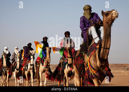 I nomadi Wodaabe cavalcare i loro cammelli come parte del Gerewol festival in Ingal, Niger Foto Stock