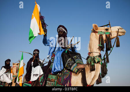 I nomadi Wodaabe cavalcare i loro cammelli come parte del Gerewol festival in Ingal, Niger Foto Stock