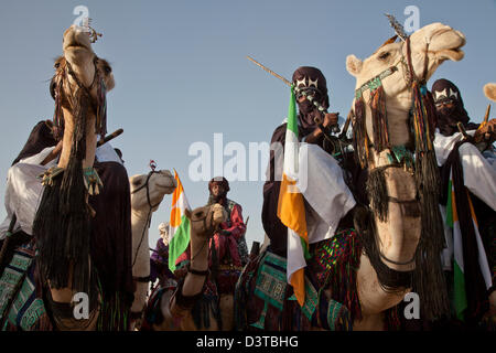 I nomadi Wodaabe cavalcare i loro cammelli come parte del Gerewol festival in Ingal, Niger Foto Stock