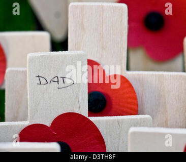 Close-up ricordo armistizio poppy day piccola croce di legno con 'Dad' scritto su di esso Foto Stock