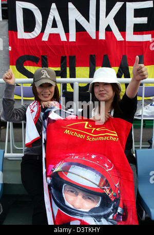 I fan giapponesi del tedesco pilota di Formula Uno Michael Schumacher tenere il pollice in alto nella parte anteriore di un banner che recita "Grazie Shumi" prima del Gran Premio del Giappone presso la pista di Suzuka, in Giappone, domenica 08 ottobre 2006. Foto: Gero Breloer Foto Stock