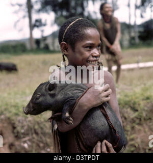 (Dpa - file) - l'immagine non datata mostra una femmina di Papua portante un maialino nelle sue braccia in Papua Nuova Guinea. La popolazione di Papua Nuova Guinea, costituita principalmente da Papuas, è molto diversificato. Il Papuas sono cacciatori raccoglitori e coltivare colture come yam, la manioca e le banane. Arco e frecce sono ancora in uso come sono gli assi di pietra e bastoni di scavo. I suini sono molto importanti come domesticat Foto Stock