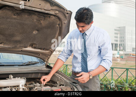 Imprenditore esaminando la sua rotta verso il basso auto, Gurgaon, Haryana, India Foto Stock