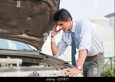Imprenditore esaminando la sua rotta verso il basso auto, Gurgaon, Haryana, India Foto Stock