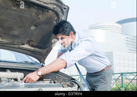 Imprenditore esaminando la sua rotta verso il basso auto, Gurgaon, Haryana, India Foto Stock