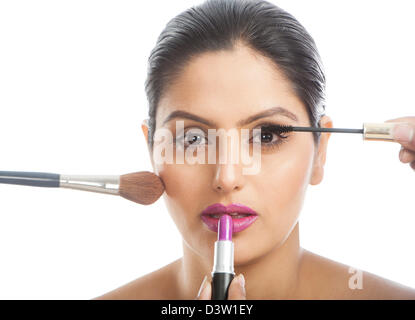 Donna applicando un assortimento di make up Foto Stock