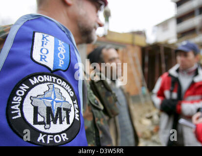 Forze armate tedesche giustificano Officer Classe I Detlef Kerkow (L) del Liaison Team di monitoraggio (LMT) parla con lavoratori edili in Mushnikovo, Kosovo, 13 dicembre 2006. Il villaggio si trova a nord di Prizren è uno dei molti villaggi pattugliato da LMT che si prende cura dei residenti" questioni. Foto: Matthias Schrader Foto Stock