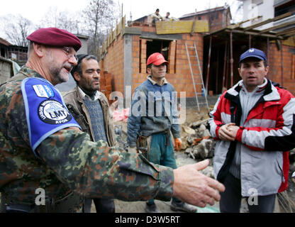 Forze armate tedesche giustificano Officer Classe I Detlef Kerkow (L) del Liaison Team di monitoraggio (LMT) parla con lavoratori edili in Mushnikovo, Kosovo, 13 dicembre 2006. Il villaggio si trova a nord di Prizren è uno dei molti villaggi pattugliato da LMT che si prende cura dei residenti" questioni. Foto: Matthias Schrader Foto Stock