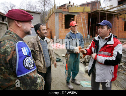 Forze armate tedesche giustificano Officer Classe I Detlef Kerkow (L) del Liaison Team di monitoraggio (LMT) parla con lavoratori edili in Mushnikovo, Kosovo, 13 dicembre 2006. Il villaggio si trova a nord di Prizren è uno dei molti villaggi pattugliato da LMT che si prende cura dei residenti" questioni. Foto: Matthias Schrader Foto Stock