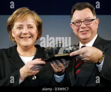 Il cancelliere tedesco Angela Merkel (L) viene consegnato un plastico per Reto Francioni (R), il CEO della Deutsche Boerse AG (Borsa tedesca), presso la sede di ricevimento di Capodanno a Francoforte, Germania, 22 gennaio 2007. Il toro e l'orso rappresentano le su e giù presso le borse. Foto: Frank Rumpenhorst Foto Stock