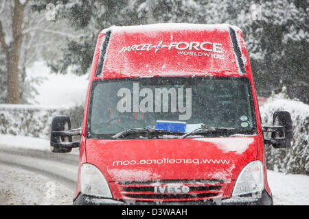 Una forza di pacchi van guidando attraverso neve pesante a Ambleside, Lake District, UK. Foto Stock