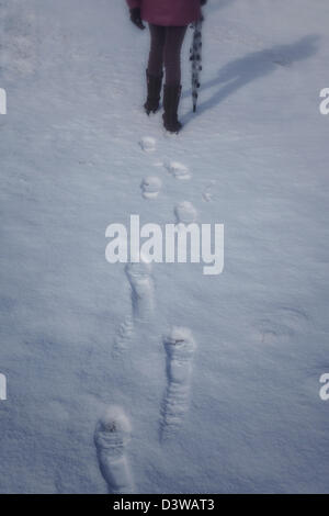 Una donna con un ombrello è a piedi nella neve Foto Stock