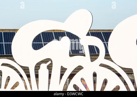 Una scuola materna a Seaton vicino a Workington, Cumbria Regno Unito, con pannelli solari sul tetto, visto attraverso cicli di opere d'arte Foto Stock