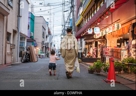 Donna con bambino a camminare per le strade di Tokyo, Giappone, Asia Foto Stock