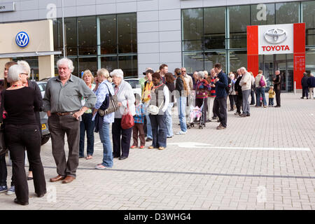 Una lunga fila di persone in attesa al di fuori di una Toyota concessionaria nel Regno Unito. Foto Stock