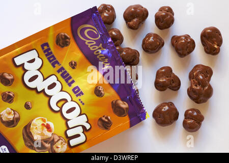 Borsa di Cadbury choc pieno di popcorn aperto con contenuto versato impostato su sfondo bianco Foto Stock