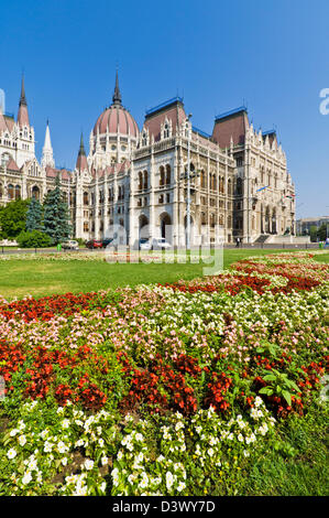 Letti di fiori nella parte anteriore del neo-gotico del parlamento ungherese edificio, progettato da Imre Steindl, Budapest, Ungheria, Europa UE Foto Stock