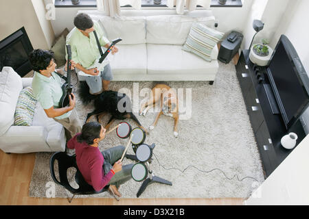 Mexian-American uomini amici gustando la riproduzione del video gioco su un Flat-Screen TV di casa Foto Stock