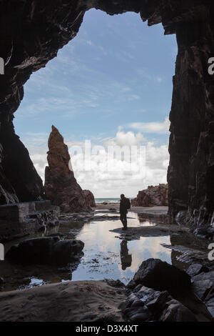 Ago roccia con la persona che si trova nella grotta Plemont, Jersey, Isole del Canale, REGNO UNITO Foto Stock