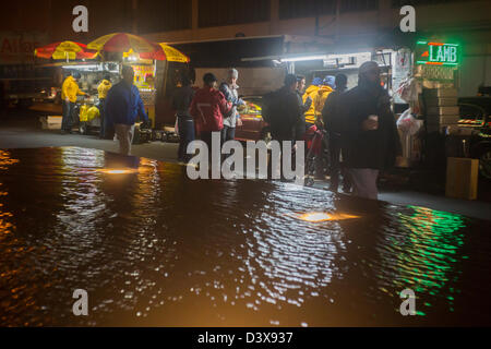 Diners line up per mediorientale il cibo di strada sulla Sesta Avenue nel centro di Manhattan a New York Foto Stock