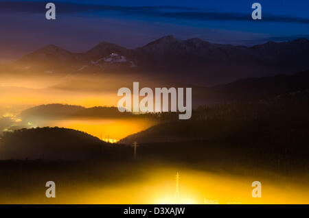 Una notte di esposizione al di sopra della città di Brasov con Piatra Mare montagne sullo sfondo Foto Stock