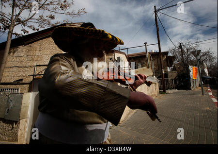 L'ebreo ortodosso che indossa un cappello sombrero suona il violino durante le vacanze ebraiche di Purim nel quartiere di Mea Shearim, un'enclave ultra-ortodossa a Gerusalemme ovest Israele Foto Stock