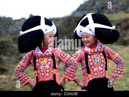 Un lungo il clacson Miao ragazze adolescenti a Tiao Hua festival di Guizhou. Foto Stock