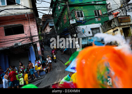 Colorati costumi di piume si vede sulla strada durante la sfilata di carnevale in favela di Rocinha, rio de janeiro, Brasile. Foto Stock