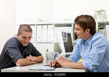 Un tardo 20's manager personale spiega il contratto di lavoro per un personale di nuova assunzione. Foto Stock