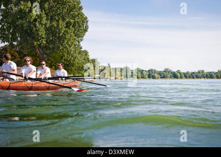 Il lavoro di squadra e il concetto di coordinamento di amici negli uomini del team a remi Foto Stock