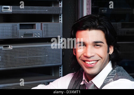 Networking Engineer sorridente in una sala server Foto Stock