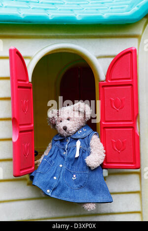 Orsacchiotto di peluche seduta di childs playhouse davanzale Foto Stock