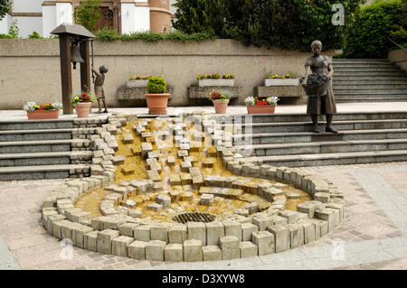 Sculture e fontana al memoriale di guerra al di fuori di una chiesa a Schieren, vicino Ettelbrück, Lussemburgo Foto Stock