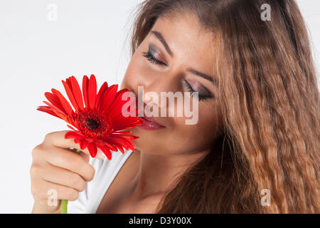 Giovane e attraente ragazza odore di gerbera Foto Stock