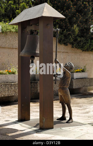 La scultura del ragazzo squillo campana al memoriale di guerra al di fuori di una chiesa a Schieren, vicino Ettelbrück, Lussemburgo Foto Stock