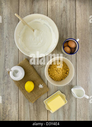 Ingredienti per fare un classico new york cheesecake al forno con limone, su tela e weathered boards. Foto Stock